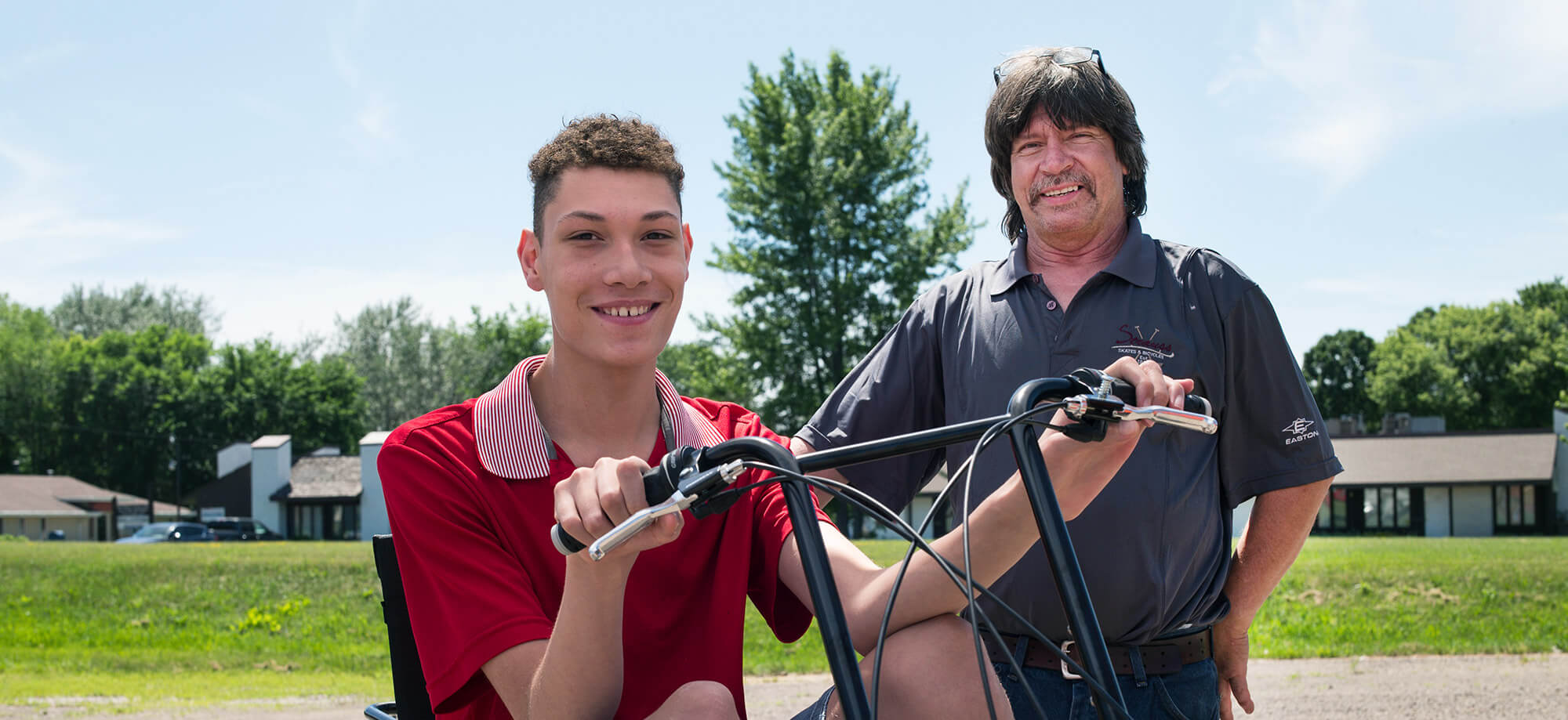 Man and boy on a bike smiling