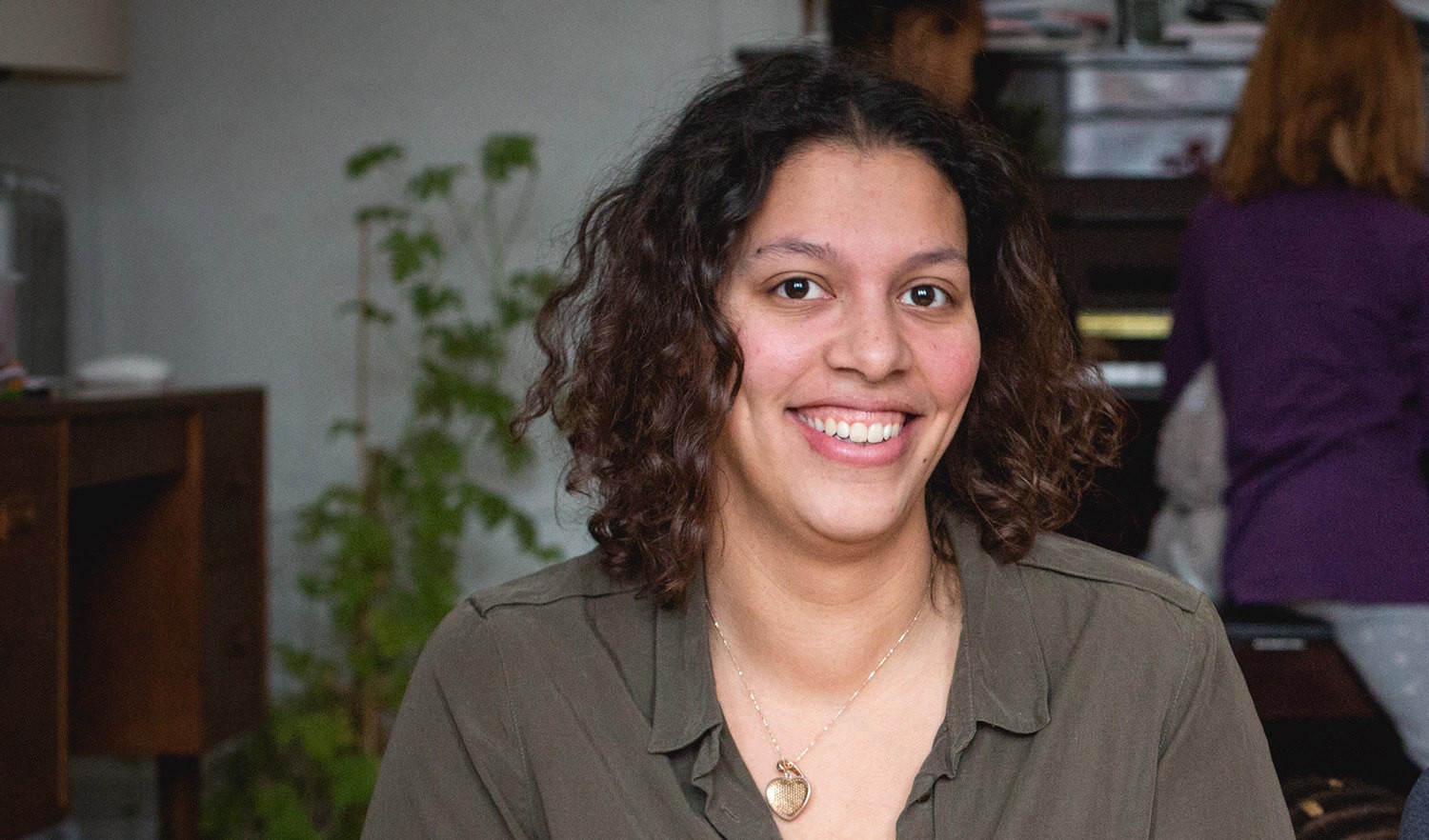 Woman with heart necklace smiling