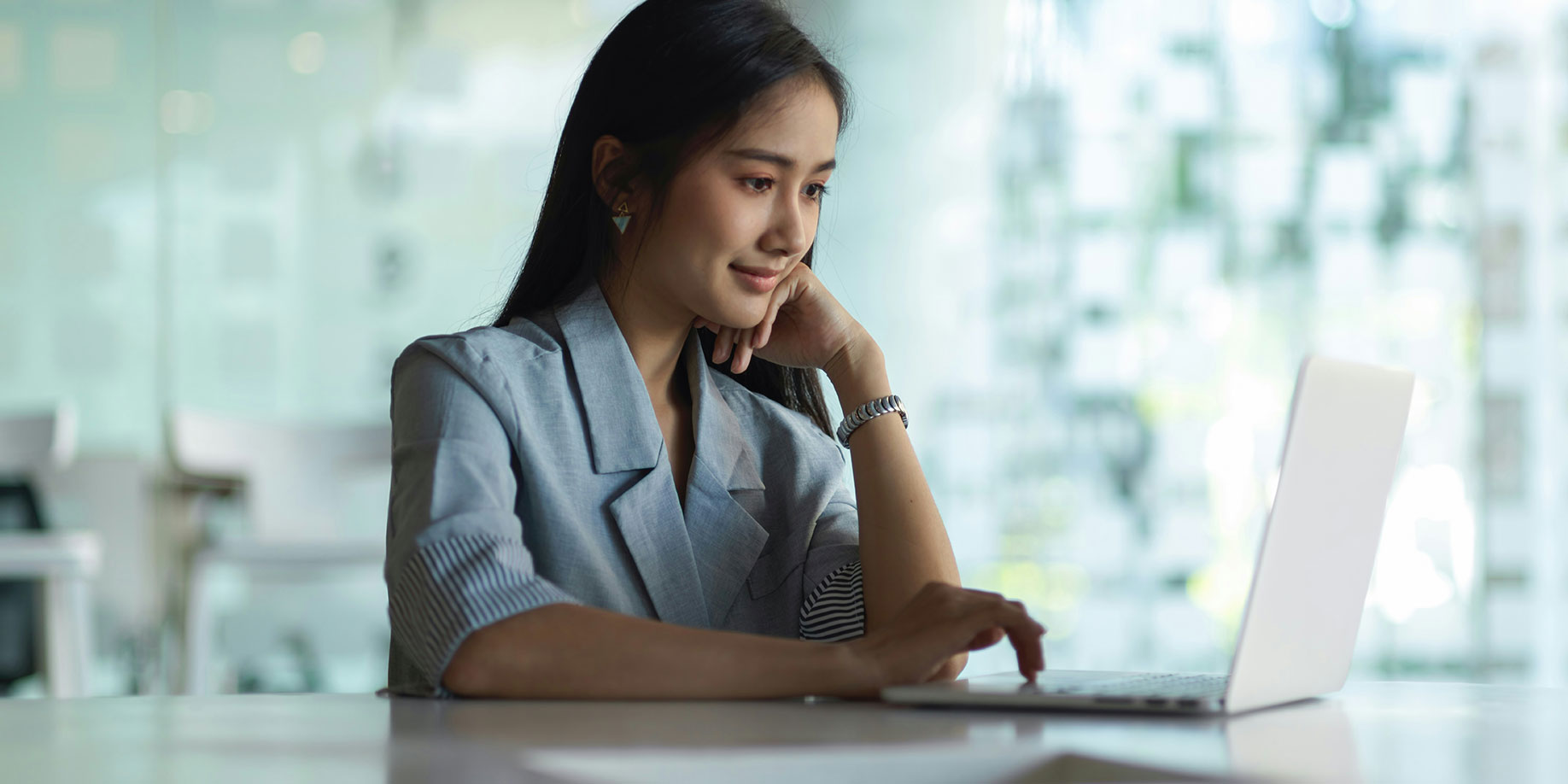 A woman smiling while using a laptop