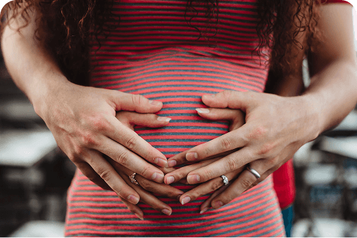 A couple holding a pregnant belly