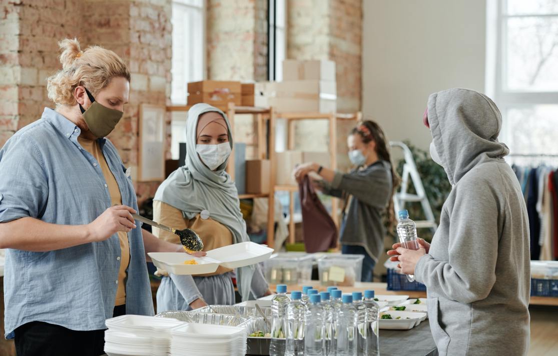 Voluntäre helfen beim austeilen von Essen. Im Artikel geht es um Crowdfunding spenden sammeln