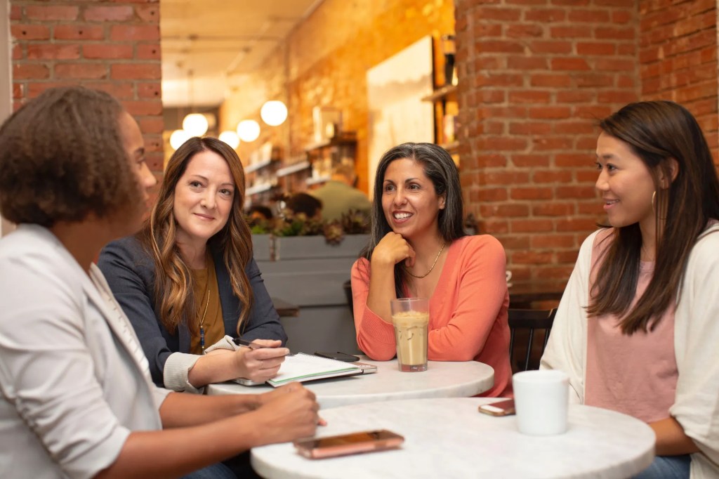 Group of business women engaged in discussion at a cafe