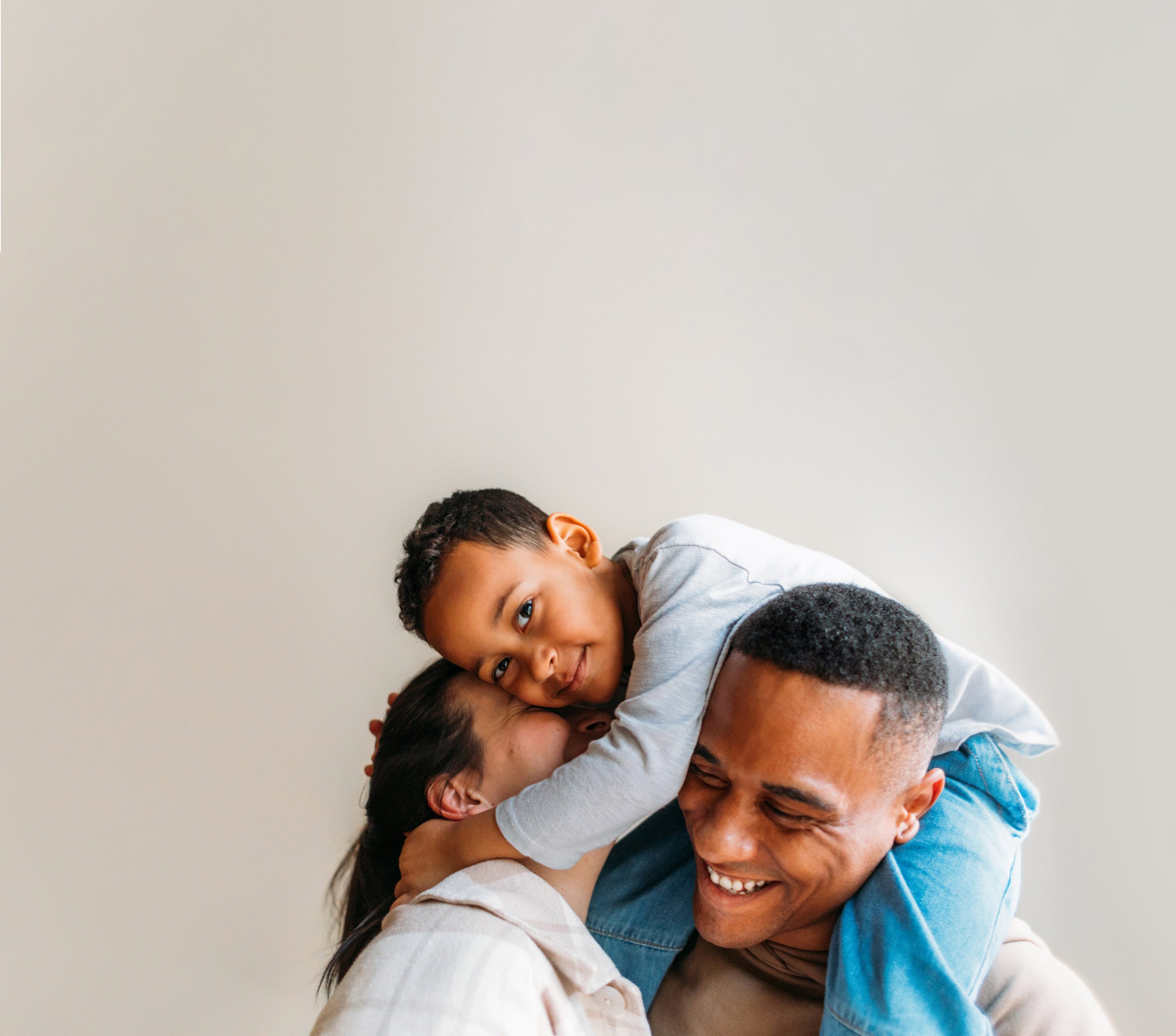 Man carrying son on his shoulders and hugging daughter