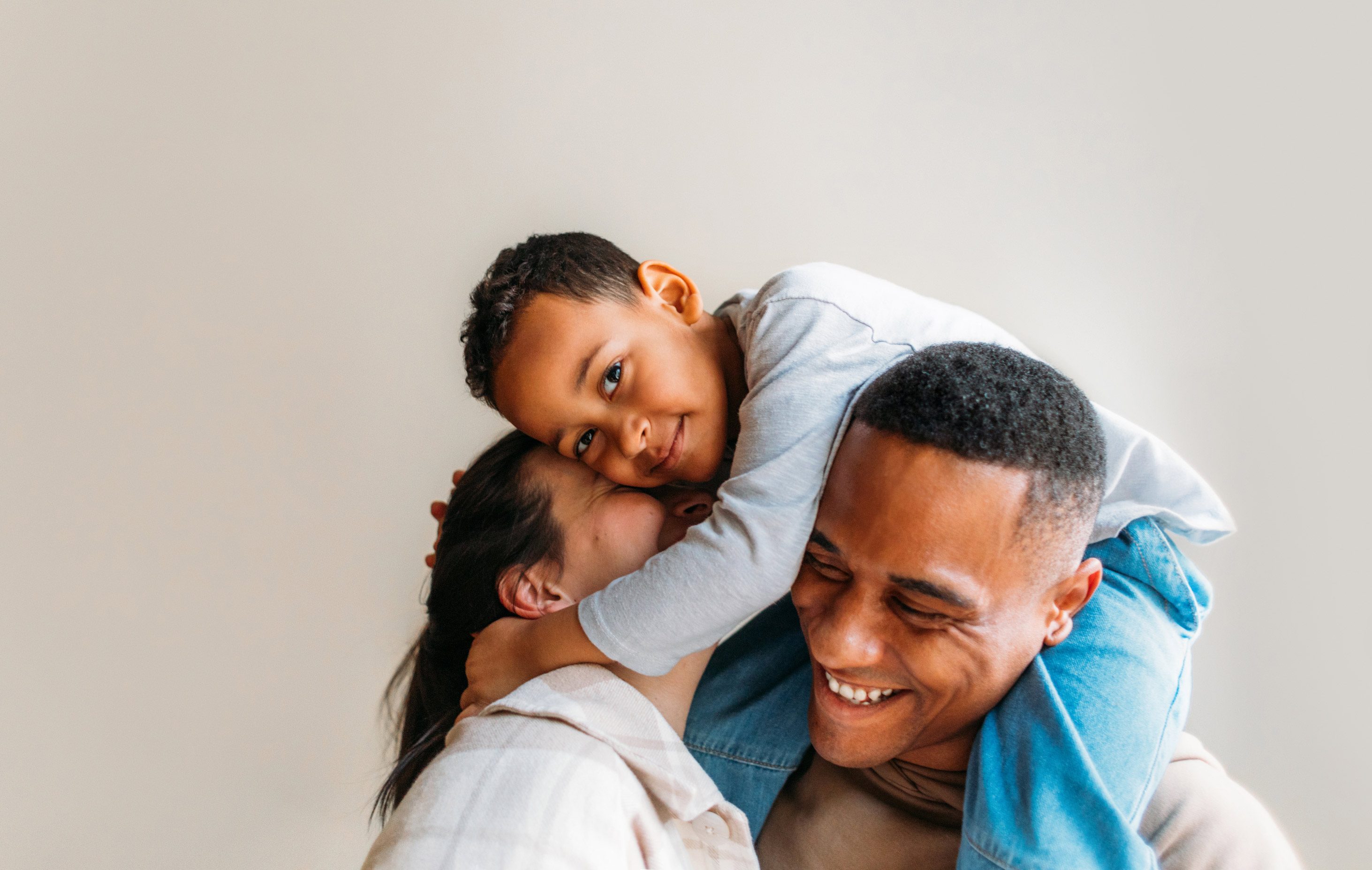 Dad carrying son and hugging daughter