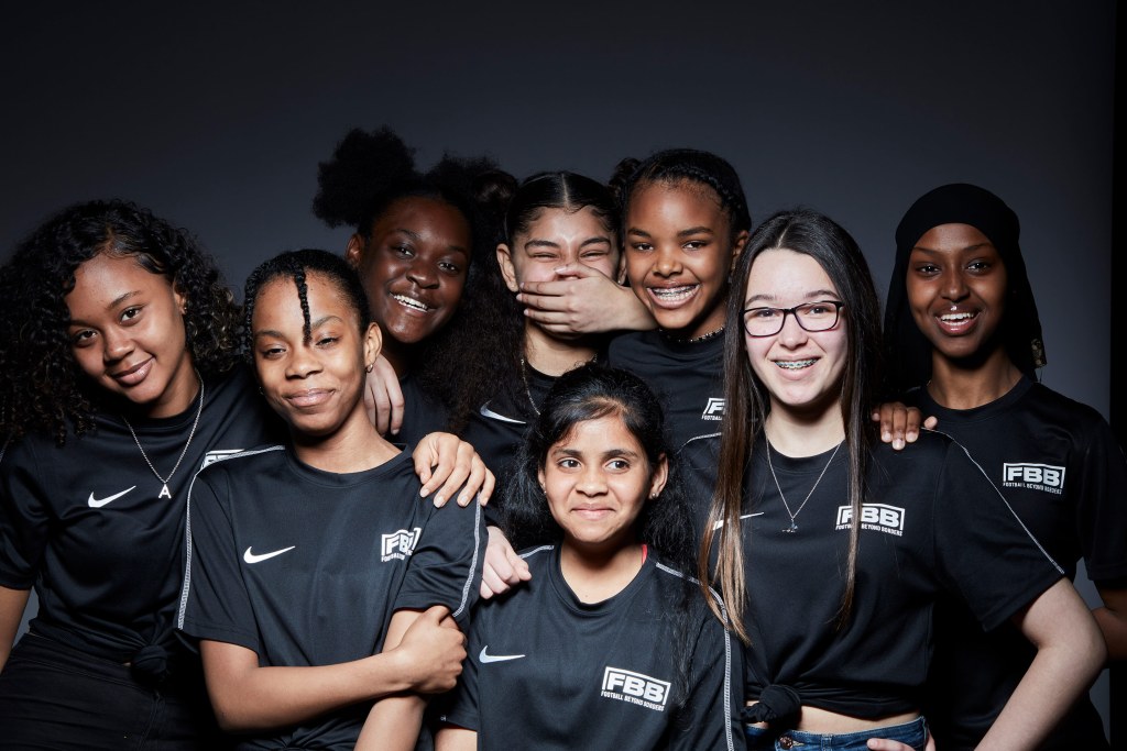 Football beyond borders brand picture of young girls playing sport